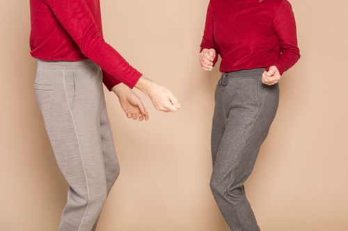 Free A fun moment of a couple dancing in casual, comfortable fashion attire with matching red tops. Stock Photo