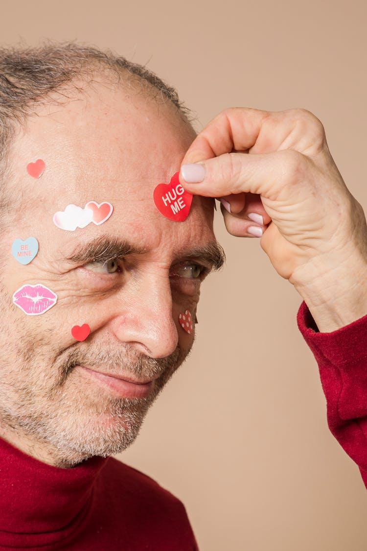 Man In Red Shirt With Heart Shaped Stickers On Face