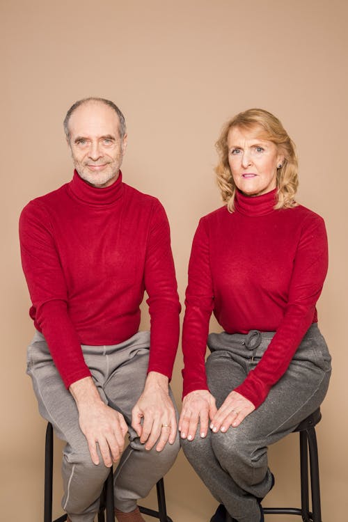 Man in Red Long Sleeve Shirt Sitting Beside Woman in Red Long Sleeve Shirt