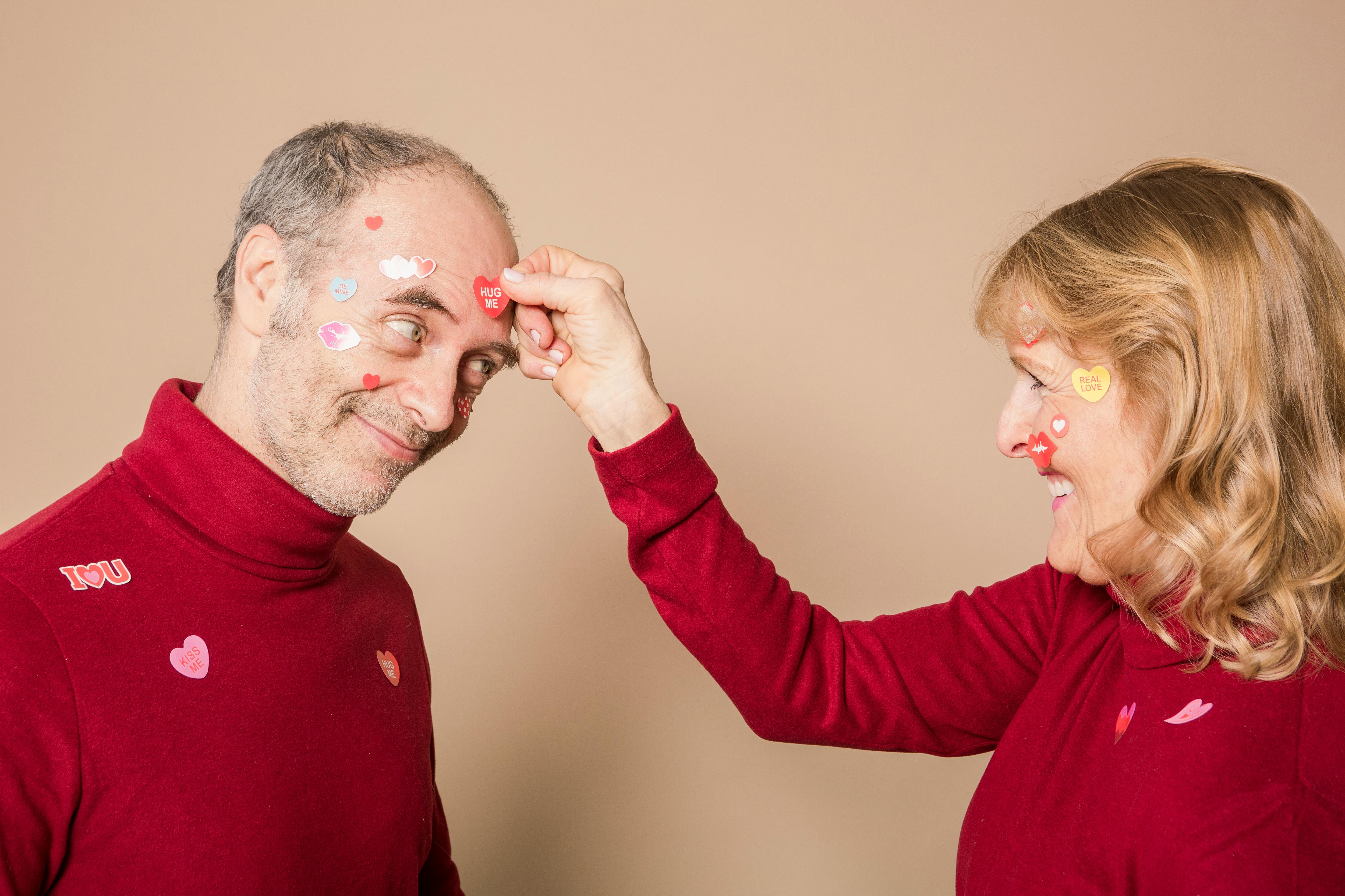 woman putting stickers on man s face