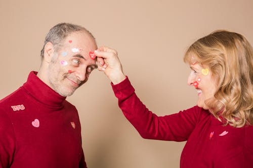 Woman Putting Stickers on Man's Face