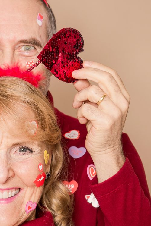 Free Smiling elderly couple holding a heart, celebrating love on Valentine's Day. Stock Photo