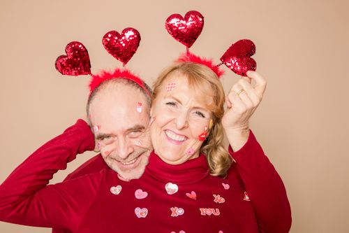 Free Joyful elderly couple wearing heart-themed accessories for Valentine's Day celebration. Stock Photo
