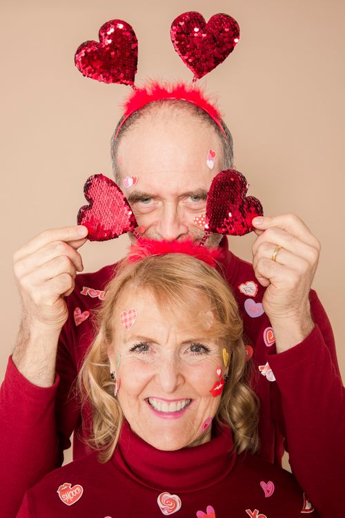 Free Elderly couple in red attire with heart accessories celebrating Valentine's Day. Stock Photo