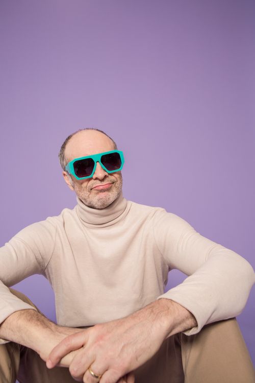 Free Confident man in trendy sunglasses and turtleneck against a purple background, exuding style and charisma. Stock Photo