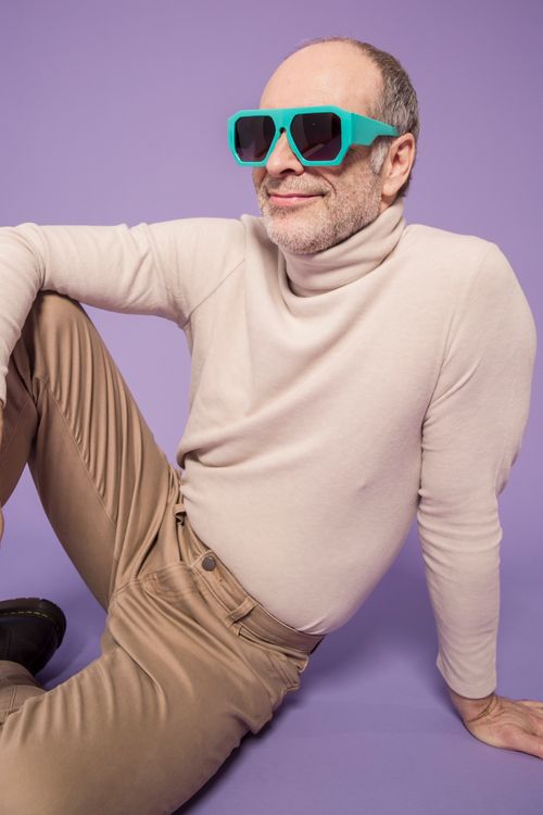 Free Elderly man in casual wear with sunglasses posing on a purple background. Stock Photo