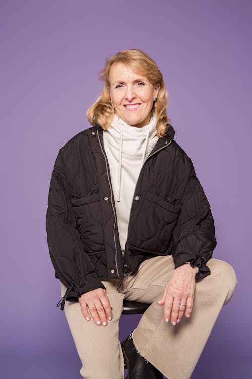 Woman in Black Jacket Sitting on Chair