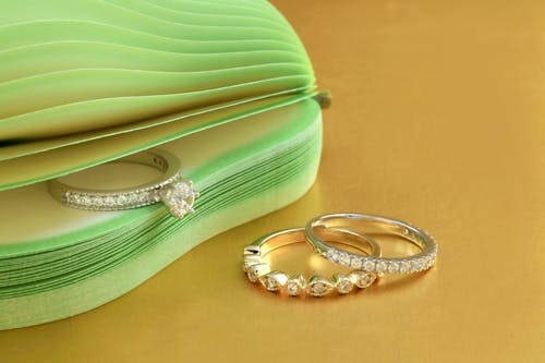 Free Silver Diamond Studded Rings on Yellow Surface  Stock Photo