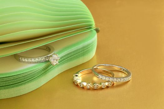 Elegant diamond rings displayed on a gold surface with a chic design.