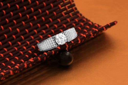 Free Close-up of a luxurious diamond engagement ring displayed on a woven textured surface, showcasing elegance and sophistication. Stock Photo