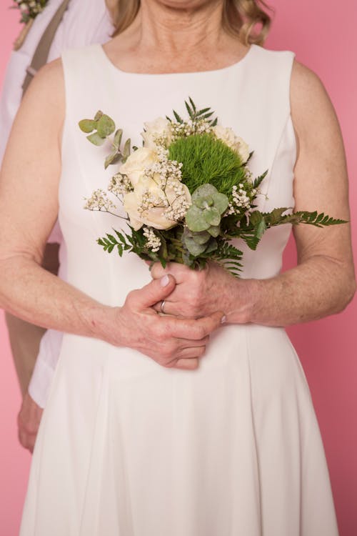 Woman in White Dress Holding White Flower Bouquet