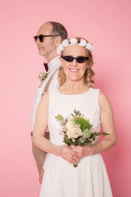 Man in White Tank Top Holding Bouquet of Flowers