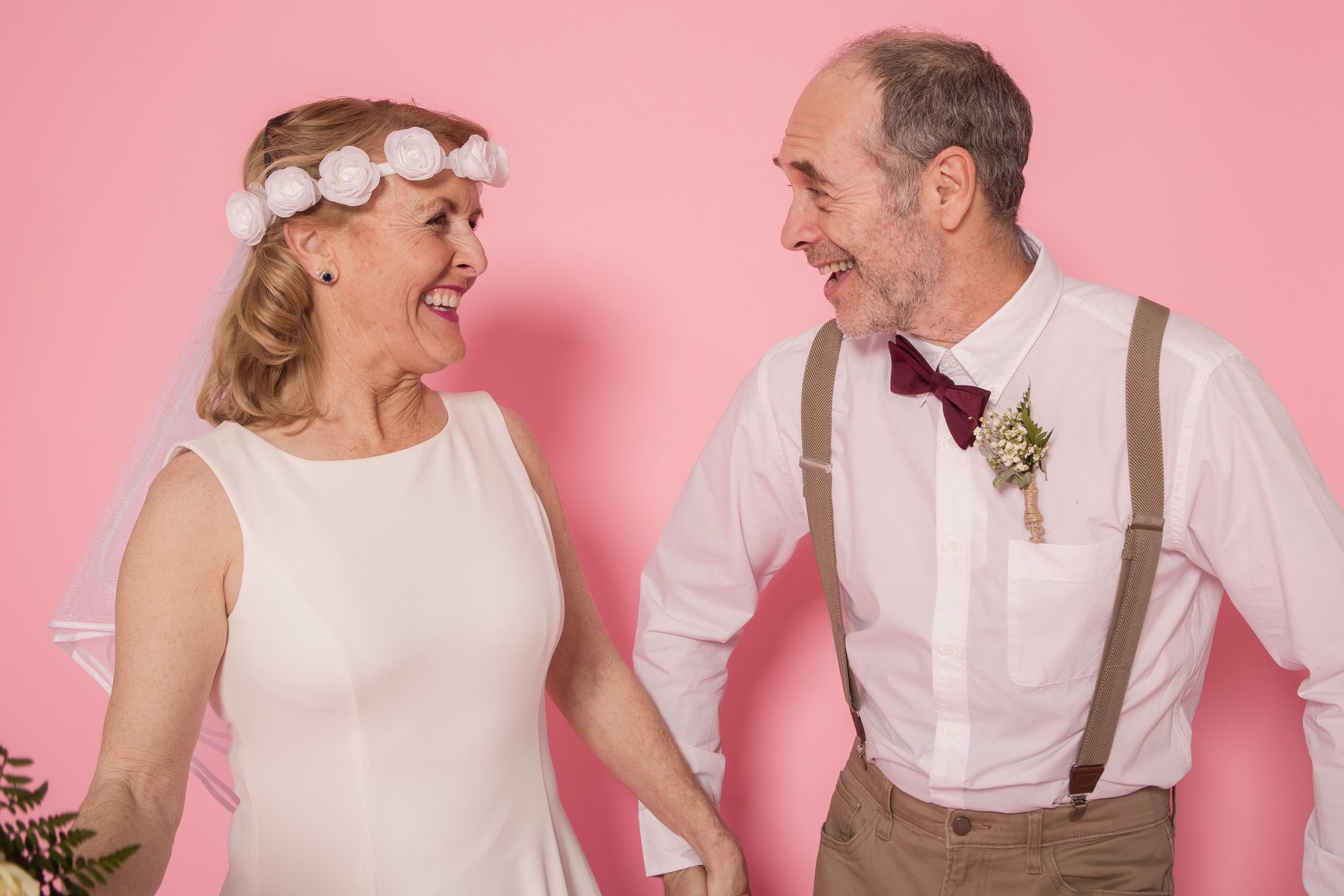 Elderly couple joyfully celebrating their love with a studio dance, highlighting a romantic moment.