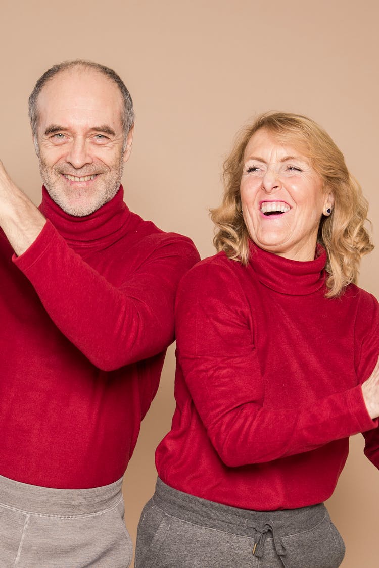 Excited Stylish Elderly Couple Smiling In Beige Studio