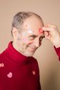 Anonymous woman attaching stickers on face of smiling husband