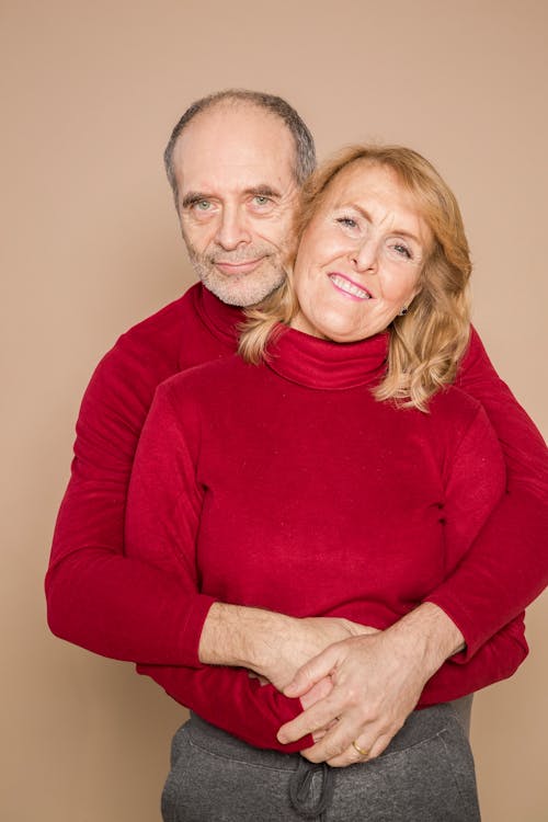 Man in Red Long Sleeve Shirt Hugging Woman in Red Long Sleeve Shirt