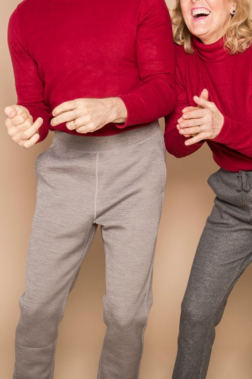 Free Crop anonymous happy middle aged spouses in similar outfits laughing and dancing against beige background in studio Stock Photo