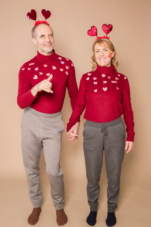 Free Elderly couple wearing matching outfits with heart decorations celebrating Valentine's Day. Stock Photo