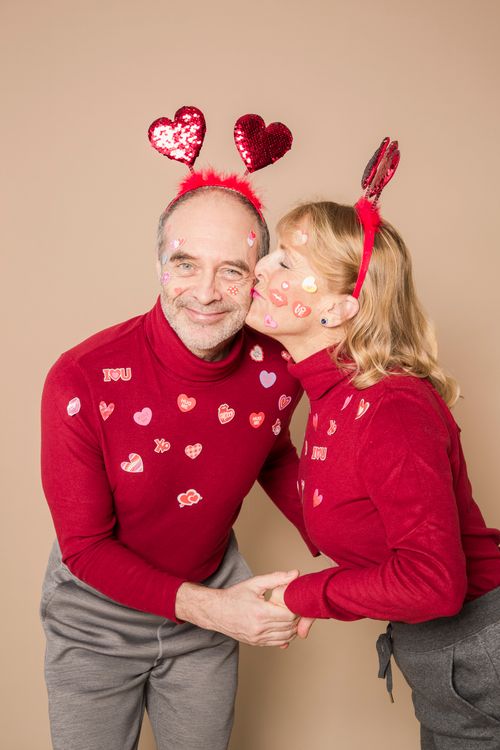 Free Cheerful elderly couple in red outfits celebrating Valentine's Day with heart accessories. Stock Photo
