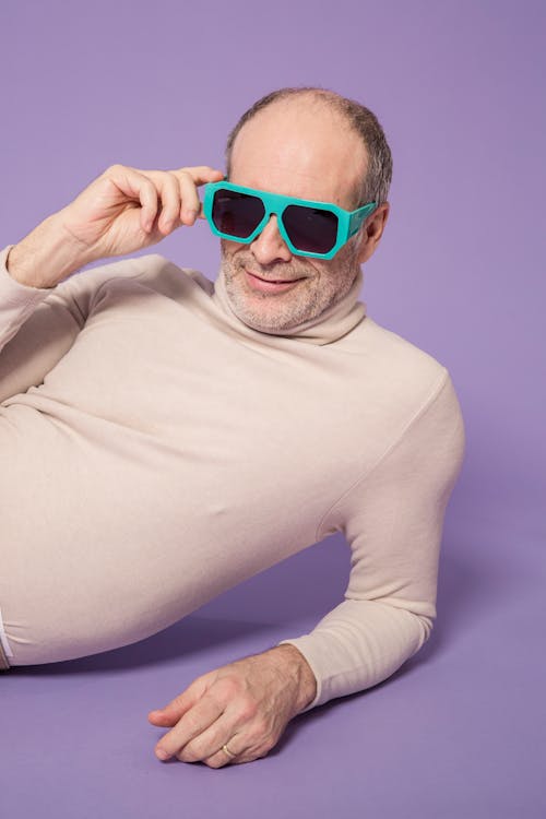 Man in Beige Turtleneck Long Sleeve Shirt Wearing Green Frame Sunglasses