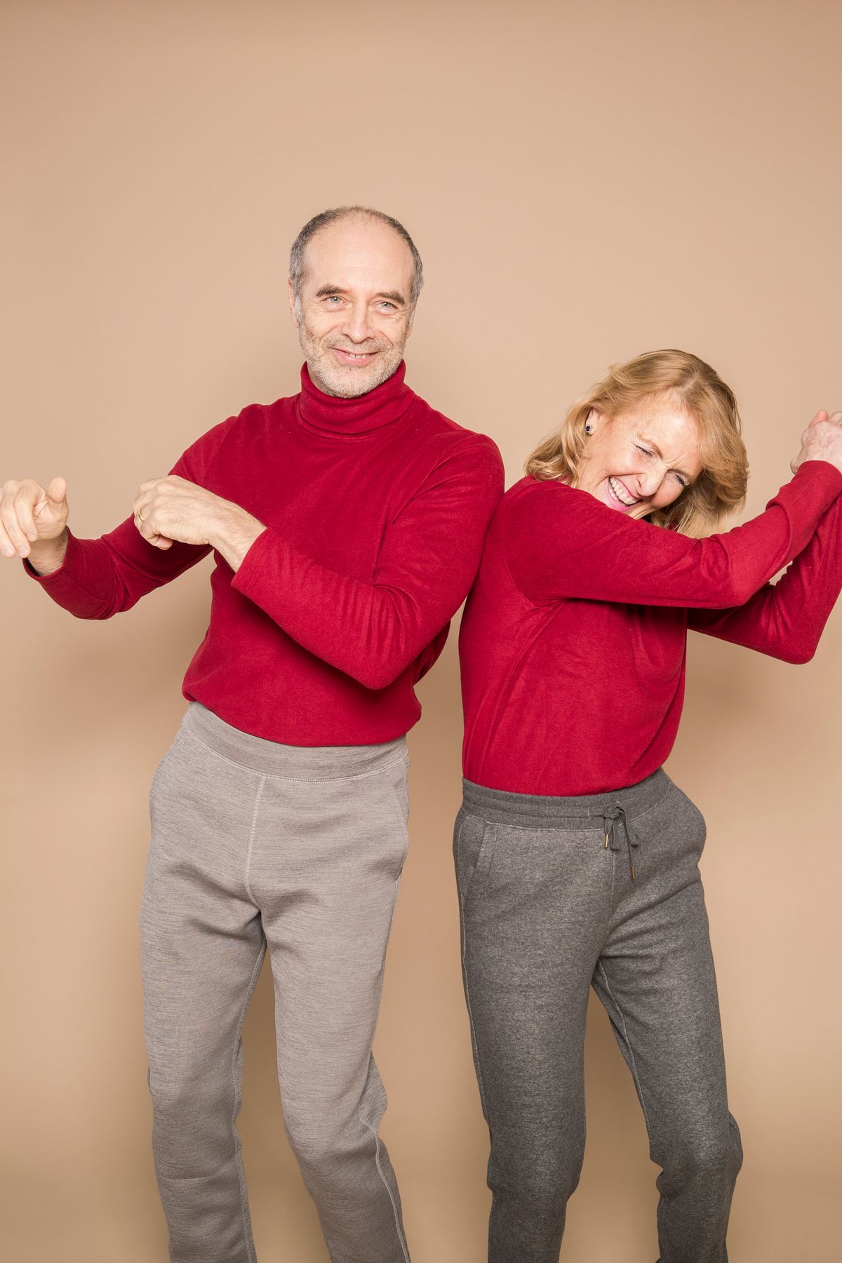 Energetic senior couple dancing together at home
