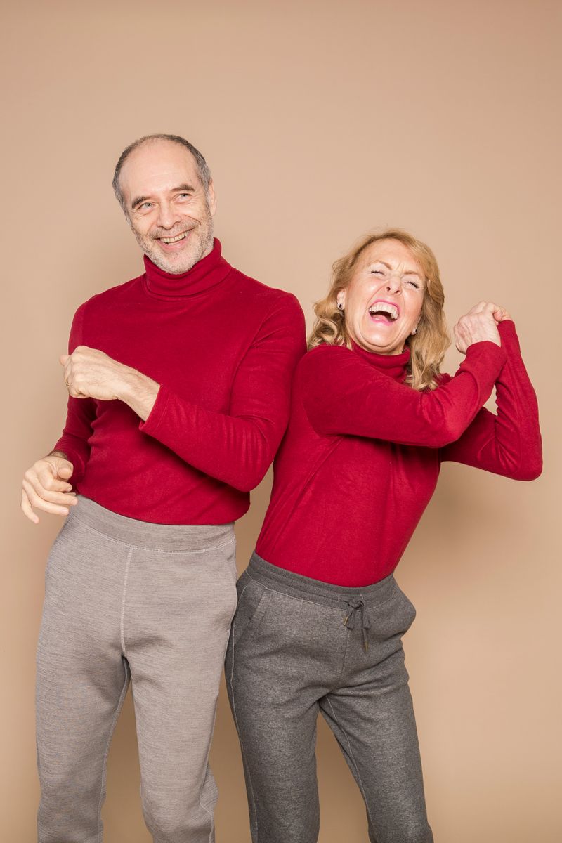 A happy senior couple dancing together in red sweaters
