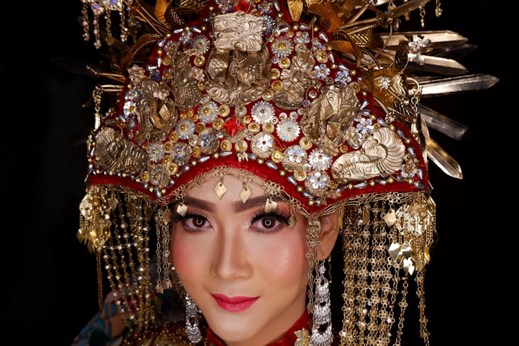 Woman In Red Lipstick Wearing Gold And Red Beaded Headdress