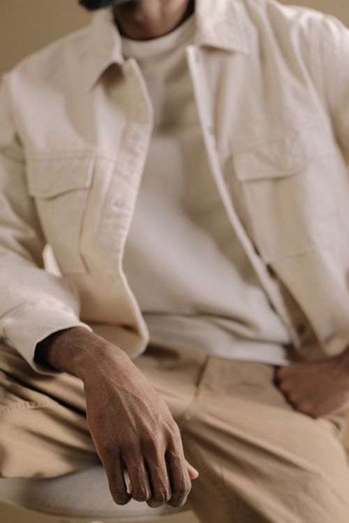 Free Close-up of a person in stylish casual clothing featuring a white jacket and khaki pants. Stock Photo