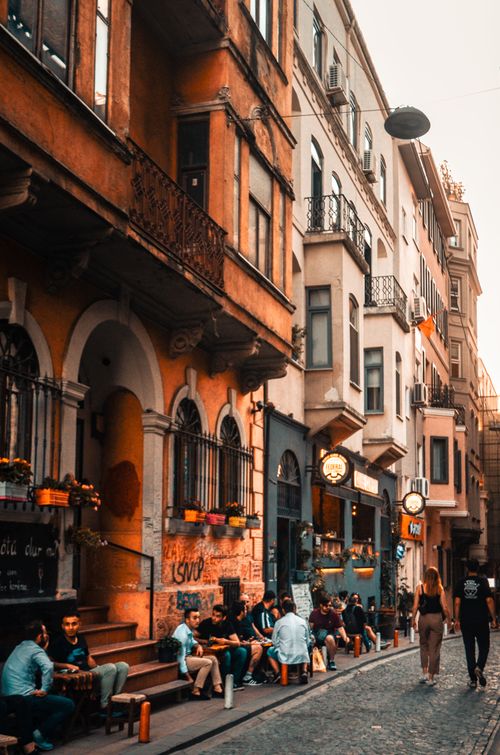 Free People on narrow street in town with old buildings near walkway in daylight Stock Photo