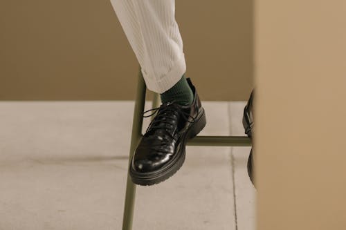 Man in White Pants and Black Leather Shoes Sitting on Chair