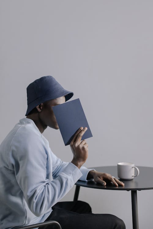 Gratis lagerfoto af afroamerikansk mand, bog, bord