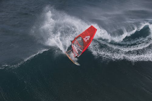 Person in Surfboard in the Wave during Daytime