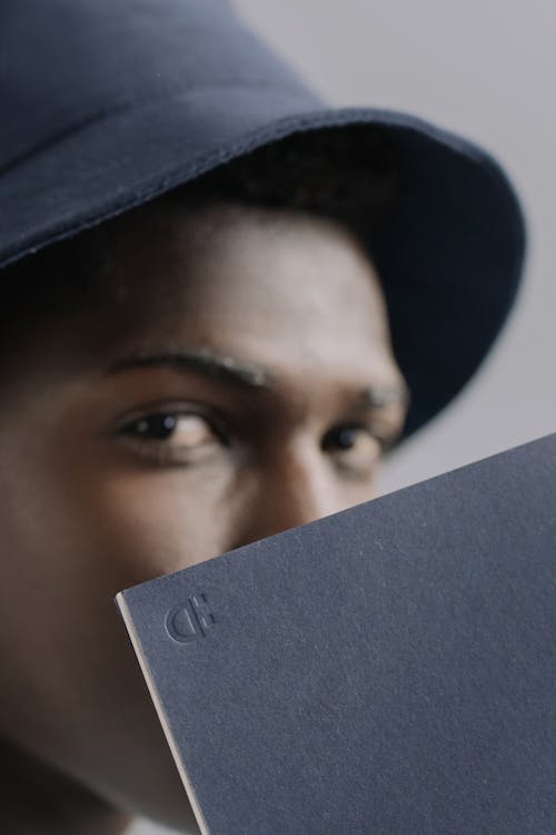 Close-Up Photo of a Notebook Near a Man