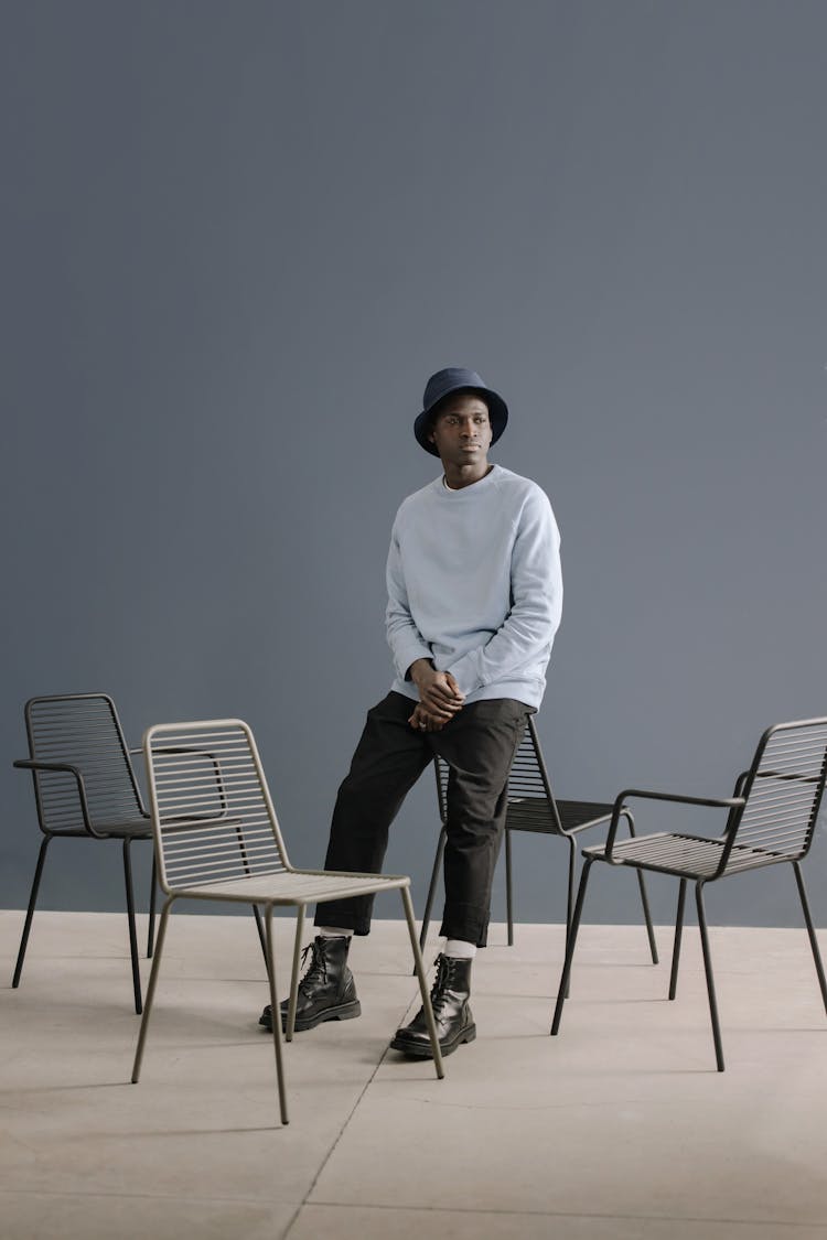 A Man In Long Sleeve Shirt Leaning On A Chair