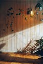 Hanging Green Plants near a Brown Wooden Wall