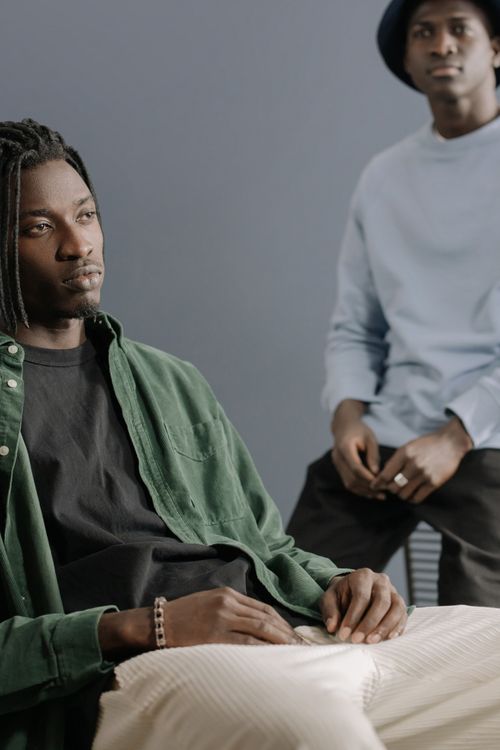Free Two fashionable African American men posing indoors with stylish clothing and relaxed expressions. Stock Photo