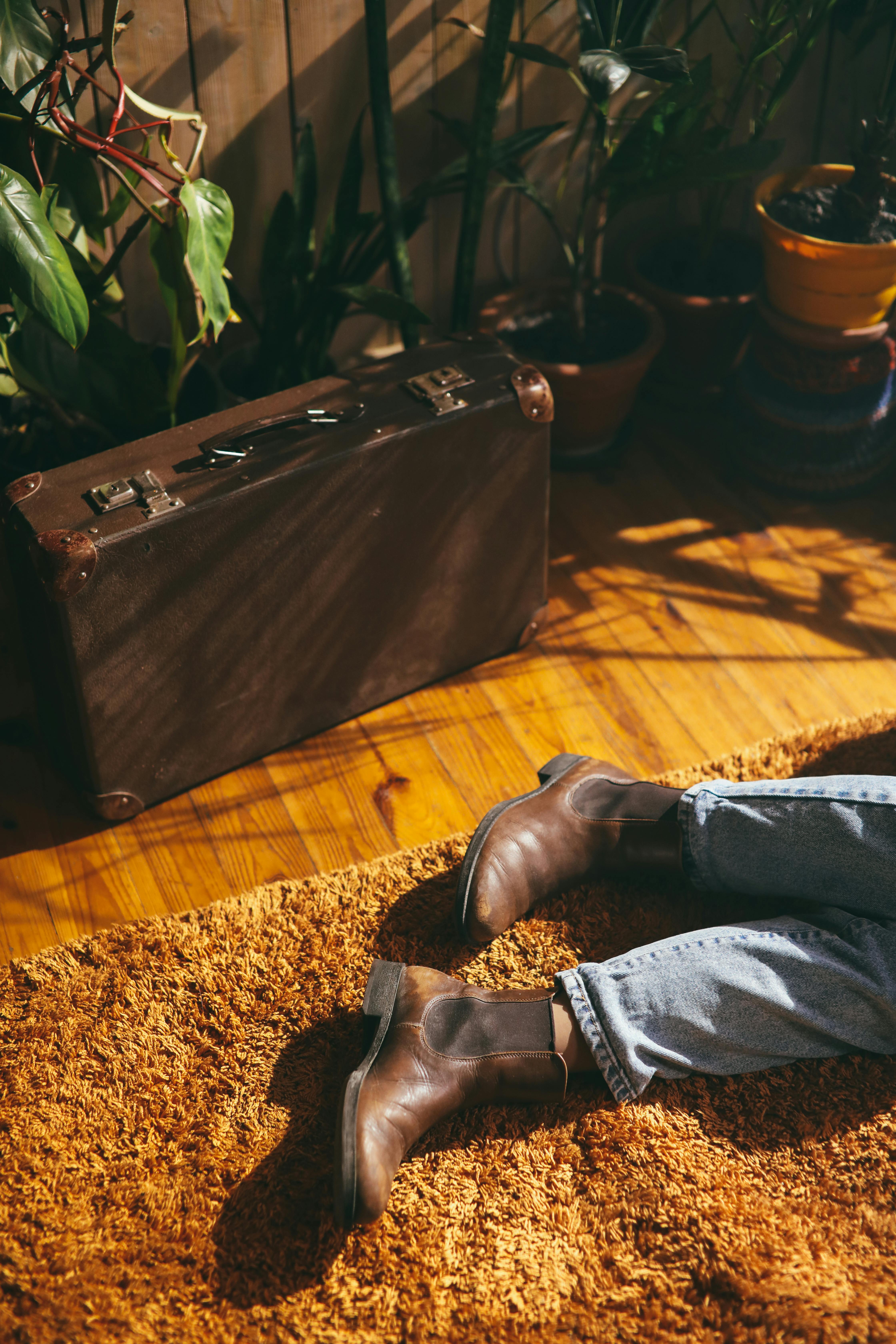 person in blue denim jeans and brown leather boots