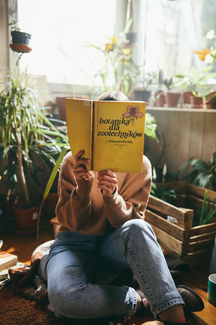 Person In Brown Knitted Sweater Reading A Book