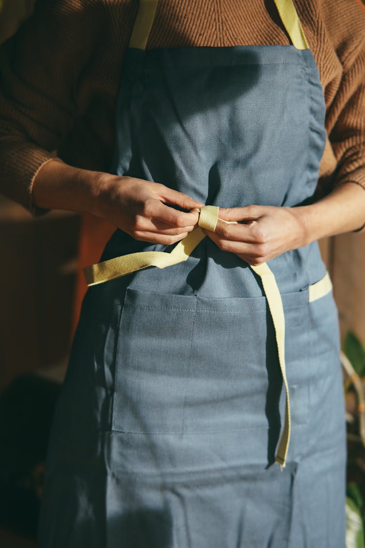 A Person Wearing A Gray And Yellow Apron