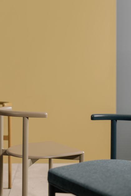 Chairs arranged against a yellow wall — photo by cottonbro studio on Pexels