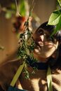 Woman in Brown Cardigan Holding Green Plant