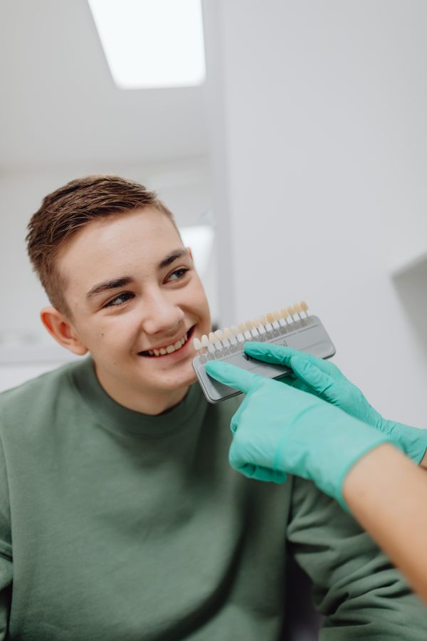 Patient matching his tooth shade with a dental shade guide