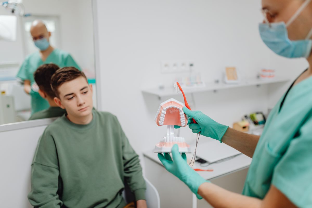Dentist holding a dental model to explain a treatment to a patient