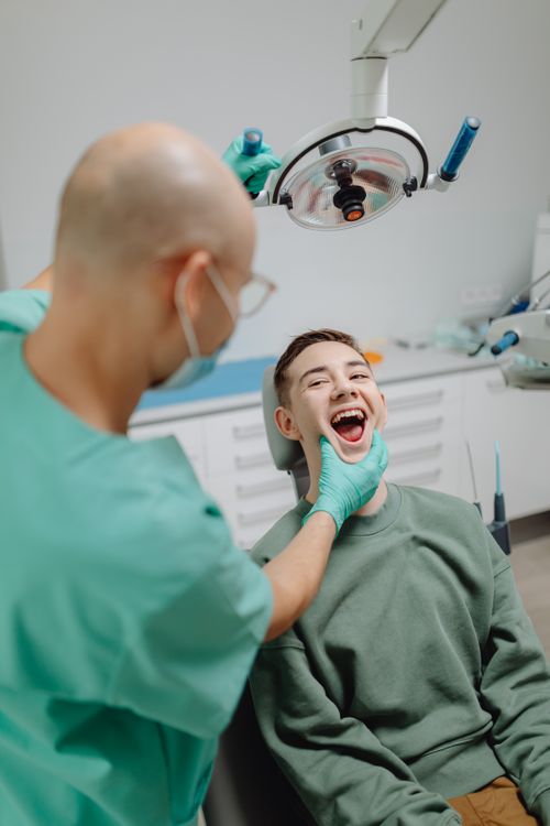 Free Dentist examining teenage patient's teeth during a checkup in a modern clinic. Stock Photo