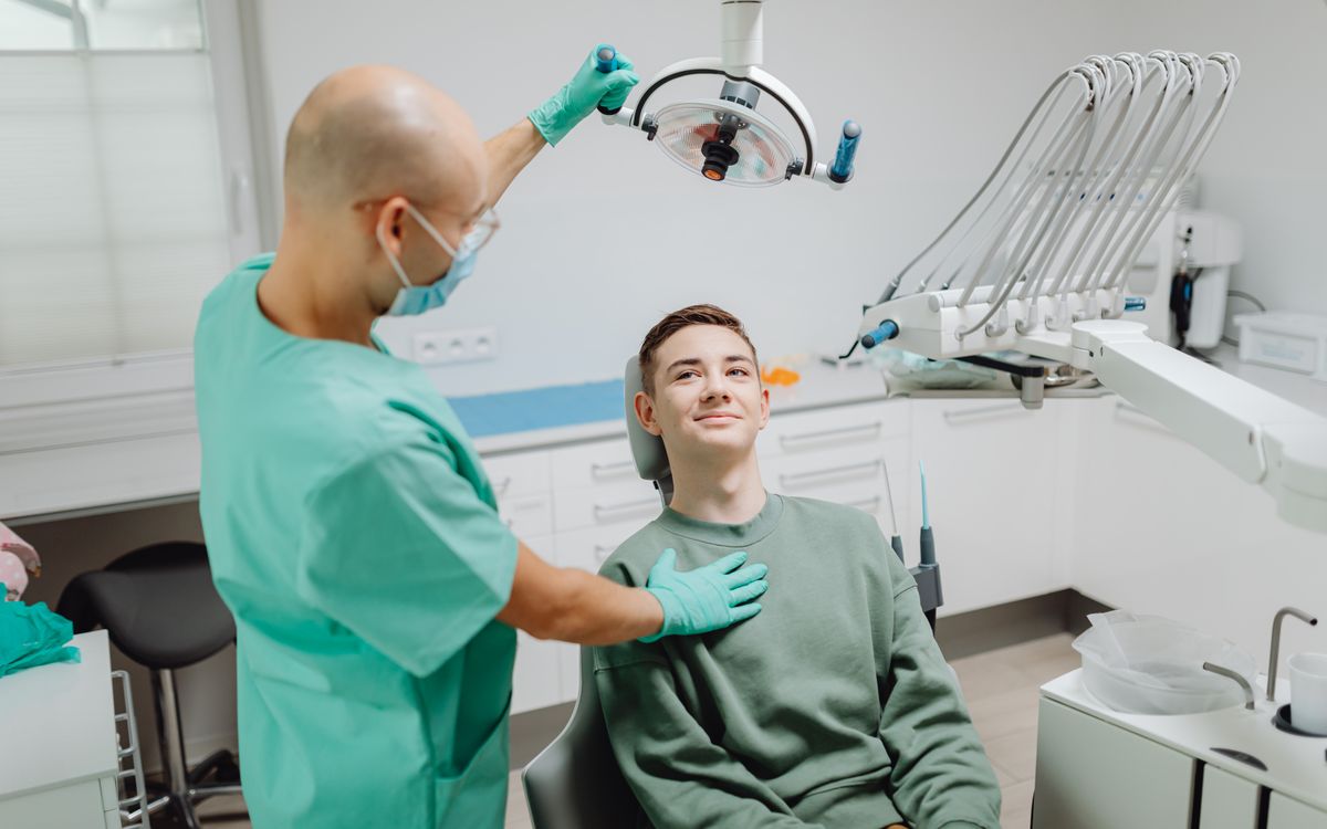 Dentist examining a patient under dental light in a modern clinic setting.