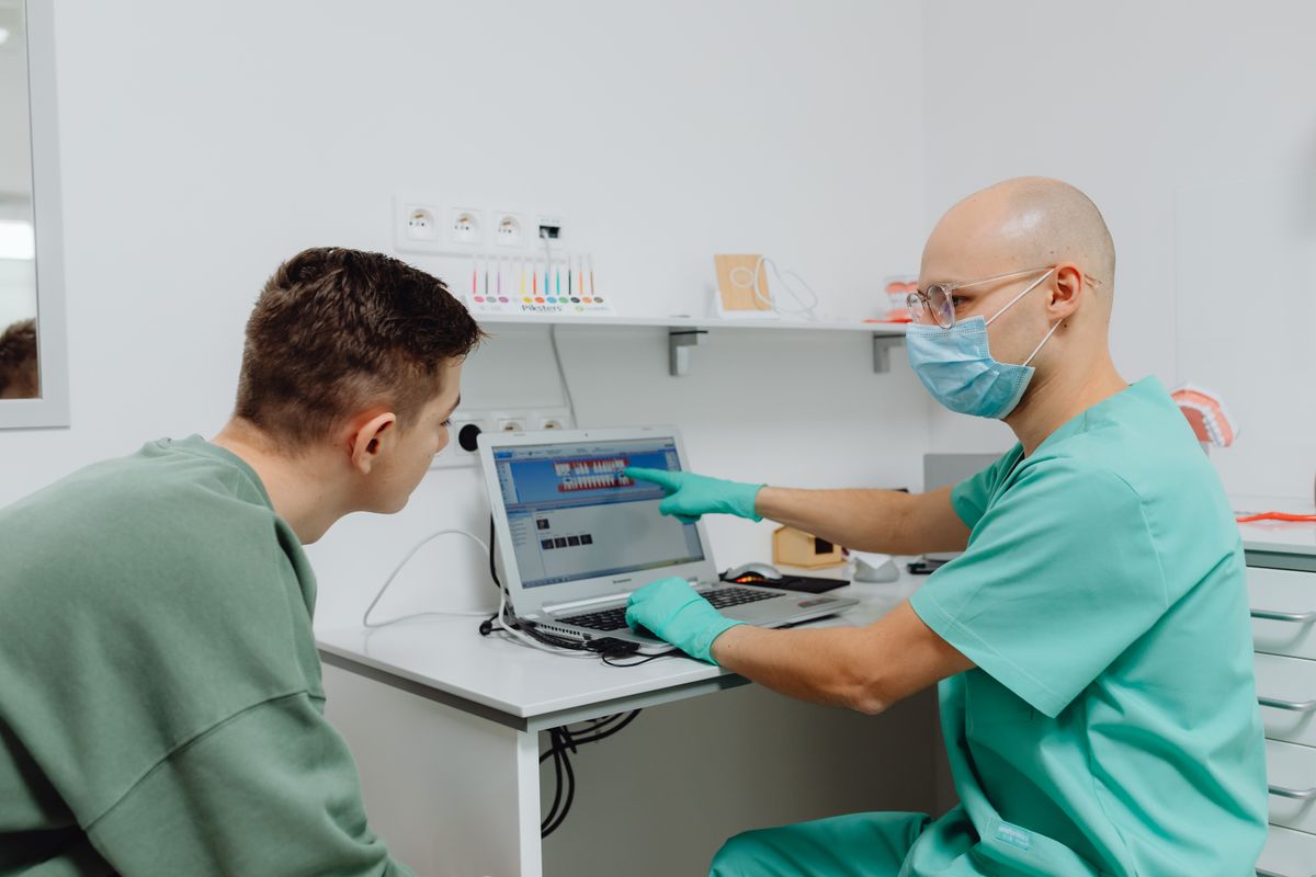 ما الذي يفعله الروبوت فعلاً في العيادة طبيب أسنان يشرح خطة العلاج لمريض عبر صور رقمية
