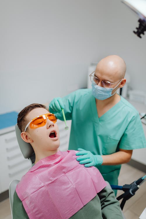 Free Dentist looking at Patient's Teeth Stock Photo