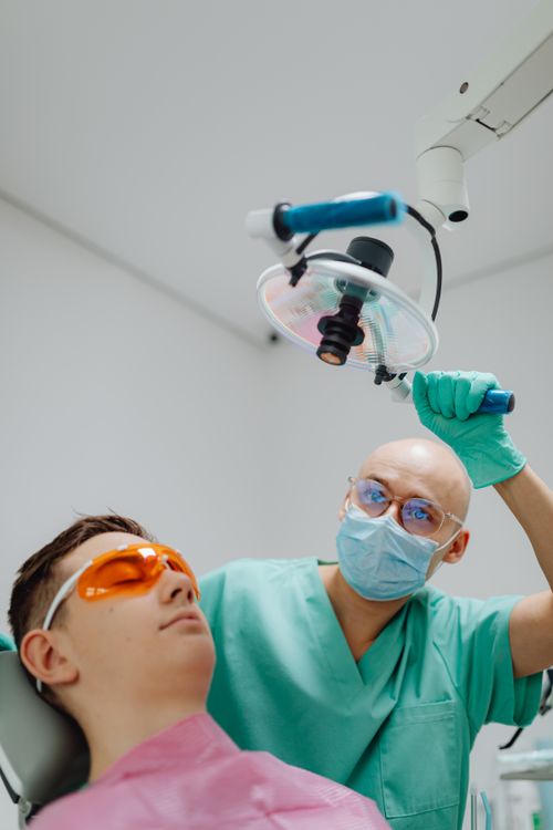 Free Dentist performing a dental checkup on a patient in a modern clinic setting. Stock Photo