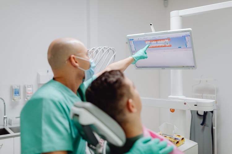 Dentist Treating Patient In Clinic