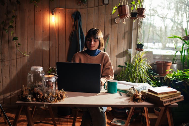 Woman Studying In A Room Full Of Indoor Plants 